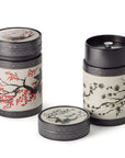 Pair of cylindrical tea canisters, elaborately decorated with pine and cherry blossom design with airtight inner lids
