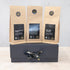 Three 100g packs of black tea on a black gift box with black and gold ribbon 