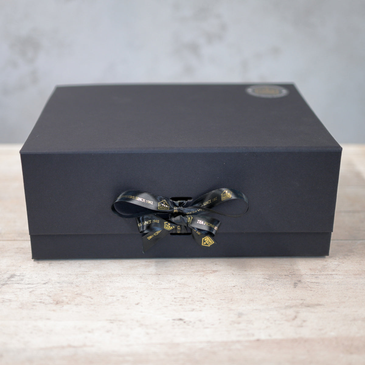 Large black gift box with black and gold ribbon