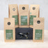 Five packs of green tea on a black gift box with a black and gold ribbon