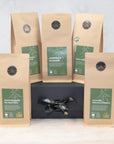 Five packs of green tea on a black gift box with a black and gold ribbon