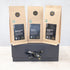 Three 100g packs of organic black tea on a black gift box with black and gold ribbon
