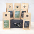 Three 100g packs of organic black tea and two 100g packs of organic green tea on a black gift box with black and gold ribbon  