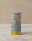 Cylindrical tea caddy with white and gold floral pattern over blue base, by The Tea House