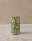 Cylindrical tea caddy with pink and white cherry blossom design on green background 